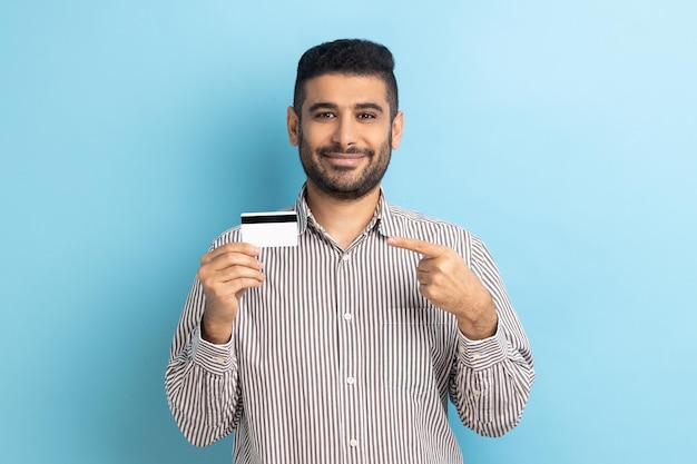 L'uomo che punta il dito contro la carta di credito guardando con un sorriso a trentadue denti consiglia sconti bancari o per lo shopping