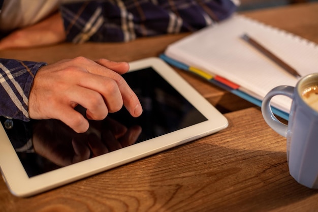 L'uomo che utilizza il tablet funziona con un tablet bianco con schermo vuoto nelle mani di un uomo