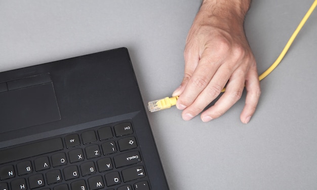 L'uomo collega il cavo di rete al laptop