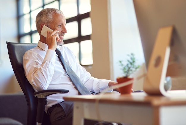 È l'uomo con cui tutti vogliono parlare Inquadratura di un uomo d'affari maturo che usa il telefono in ufficio