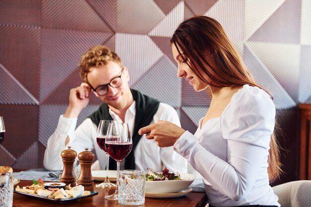 L'uomo con gli occhiali è con la donna All'interno del nuovo moderno ristorante di lusso