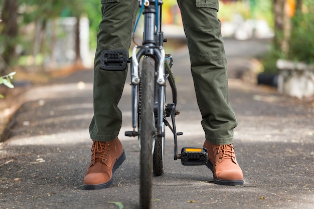 L&#39;uomo con i pantaloni cargo in sella a una bicicletta in giardino