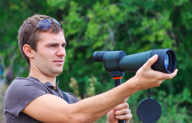 L'uomo con il cannocchiale guarda il bersaglio. Uomo positivo con telescopio