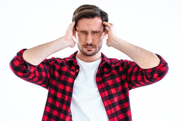 L'uomo con il mal di testa in piedi sullo sfondo bianco