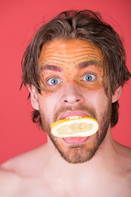 L'uomo con il trucco alla moda creativo tiene il limone, vitamina