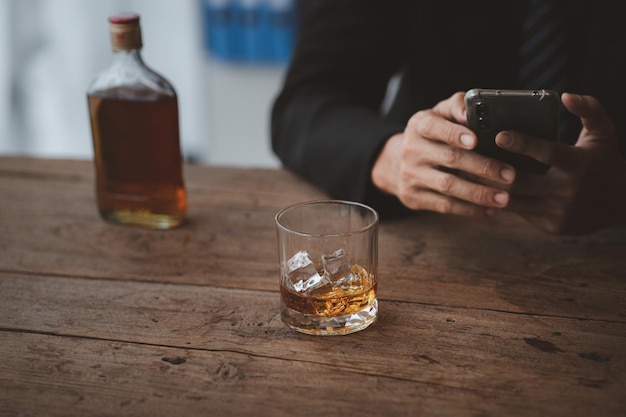 L'uomo con in mano un bicchiere di brandy sta bevendo brandy in un bar che beve alcol compromette la capacità di guida e può danneggiare la salute Il concetto di bere alcolici