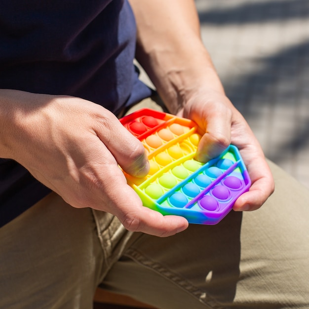 L'uomo con l'arcobaleno antistress è un giocattolo pop-it all'aperto