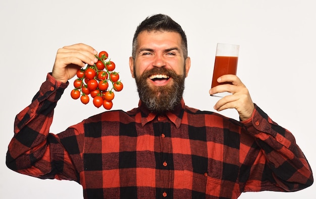 L'uomo con la barba tiene un bicchiere di succo e verdure