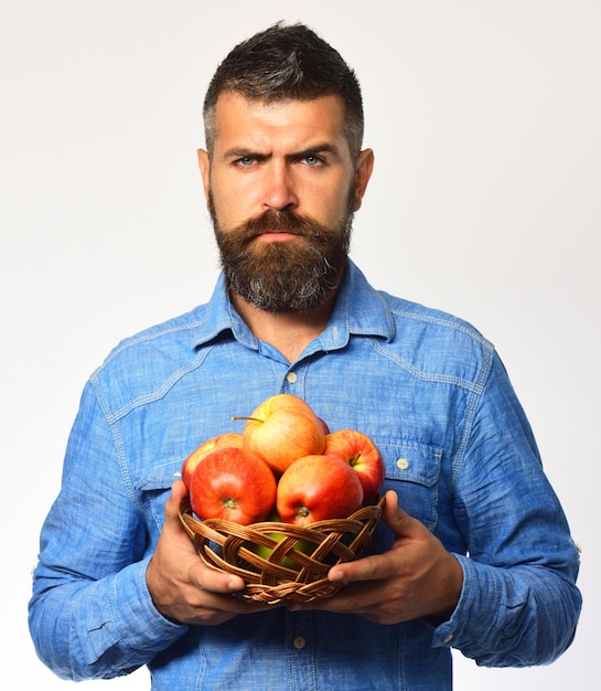 L'uomo con la barba tiene una ciotola di vimini con frutta