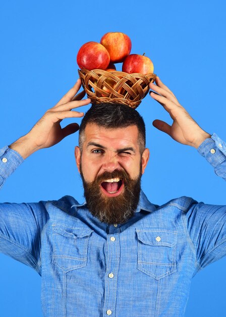 L'uomo con la barba tiene una ciotola di vimini con frutta