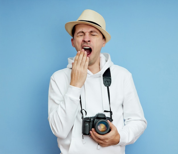 L'uomo con la macchina fotografica è stanco e sbadiglia