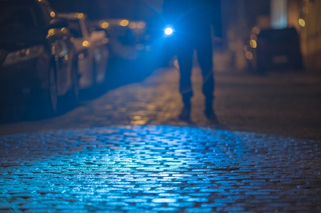 L'uomo con una torcia ispeziona la strada. Serata notturna