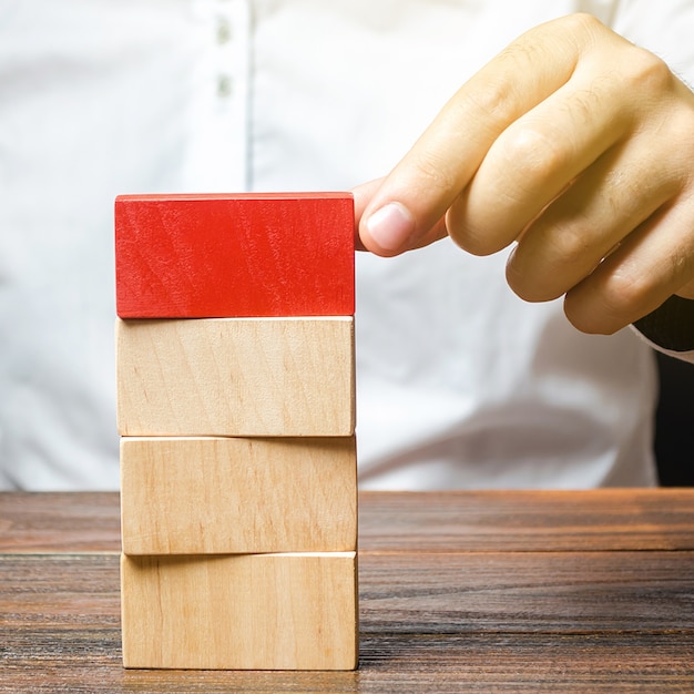 L'uomo costruisce una torre di blocchi