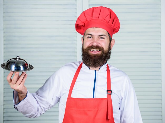 L'uomo culinario della cucina tiene il vassoio del piatto della cucina nel ristorante Cucina sana del cibo Hipster maturo con la barba Cibo biologico a dieta Ricetta dello chef dell'uomo con la barba felice Servizio amichevole servire il cibo