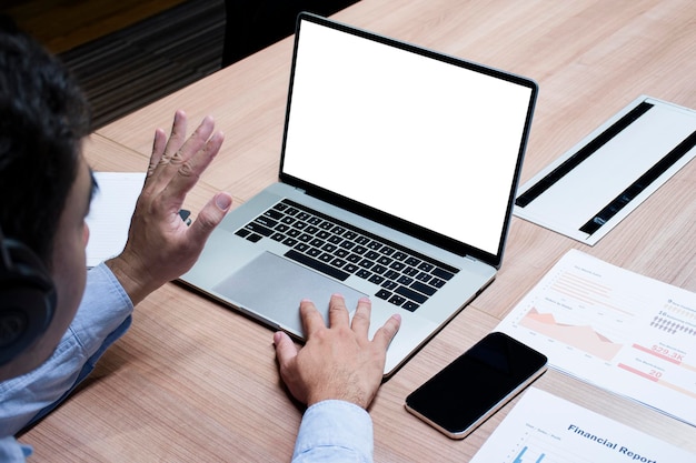 L'uomo d'affari alza la mano con lo sfondo dello schermo bianco mock up sul laptop display