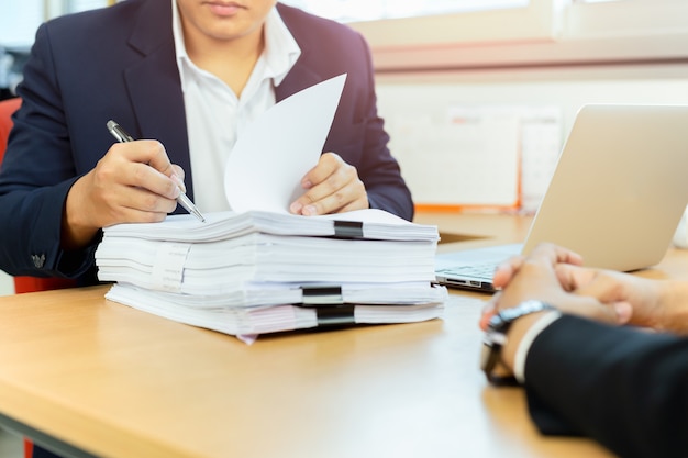 L&#39;uomo d&#39;affari asiatico ed il suo assistente che firmano il documento di firma funzionano in ufficio.