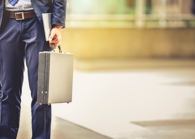 L&#39;uomo d&#39;affari che porta la cartella va a lavorare nella sua routine quotidiana con determinazione