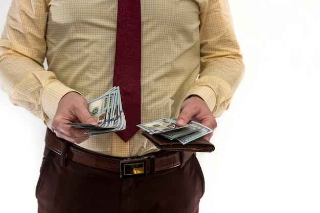 L'uomo d'affari estrae la banconota da 100 dollari dal portafoglio per effettuare un acquisto o un affitto, isolato su bianco. L'uomo ci tiene soldi