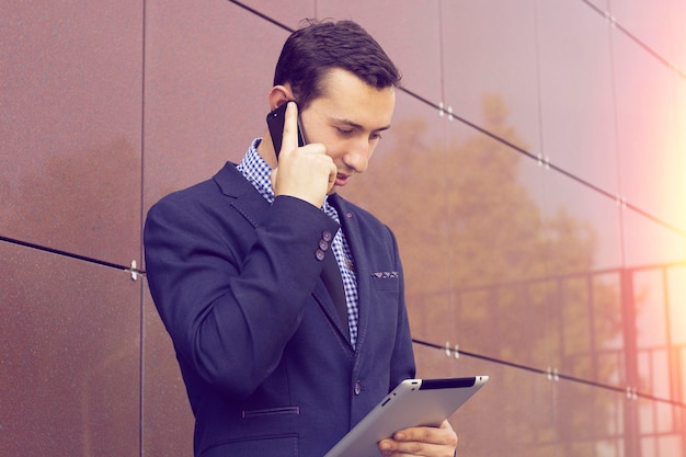 L'uomo d'affari ha detto dell'incontro per telefono. L'uomo tiene il tablet.