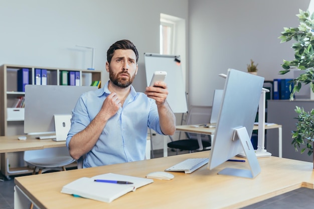 L'uomo d'affari lavora durante il giorno in un ufficio moderno l'uomo tiene in mano il condizionatore d'aria calda riduce la temperatura dell'aria