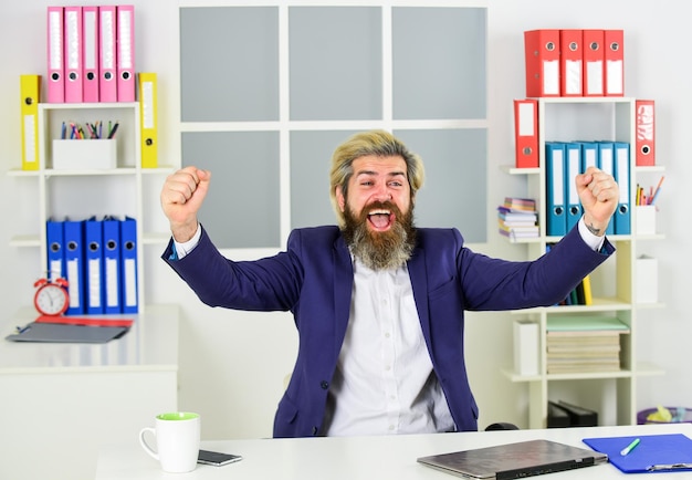 L'uomo d'affari si siede nel lavoro d'ufficio online sul computer felice uomo d'affari professionale al computer portatile uomo d'affari che indossa abiti casual intelligenti bell'uomo che beve caffè dalla tazza valore e valore