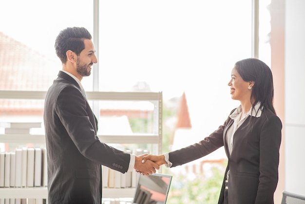 L'uomo d'affari stringe la mano alle donne d'affari che concordano sulle partnership