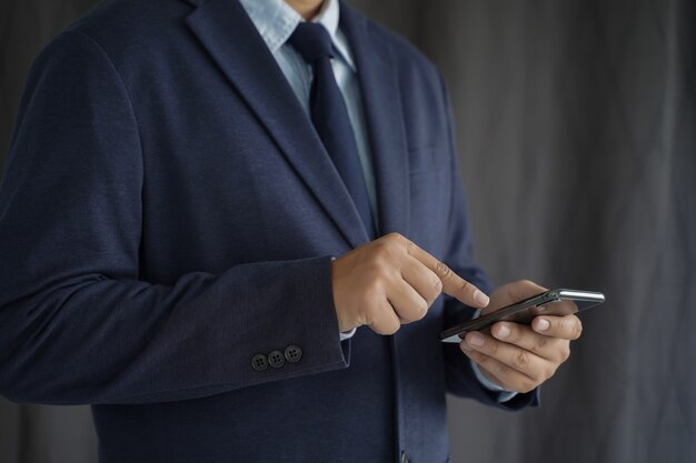 L&#39;uomo d&#39;affari tenere lo smartphone sulla strada e copiare lo spazio.