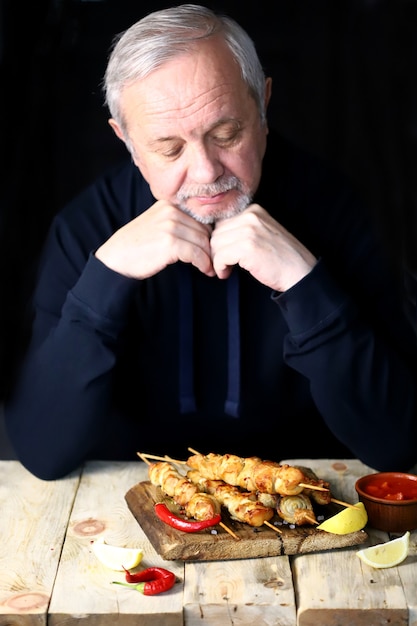 L'uomo dai capelli grigi prega prima di mangiare.