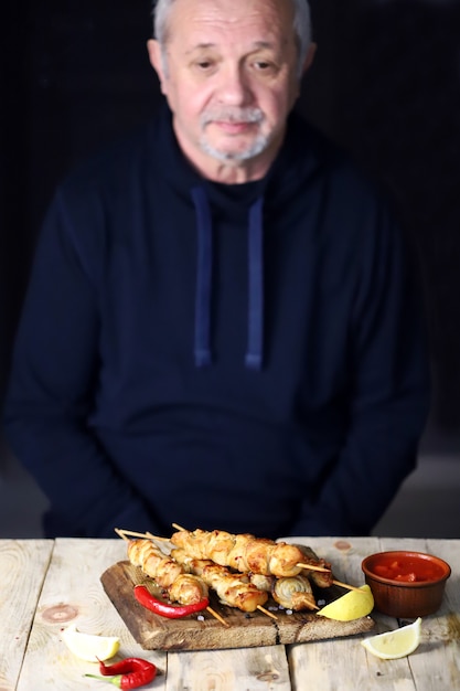 L'uomo dai capelli grigi prega prima di mangiare.