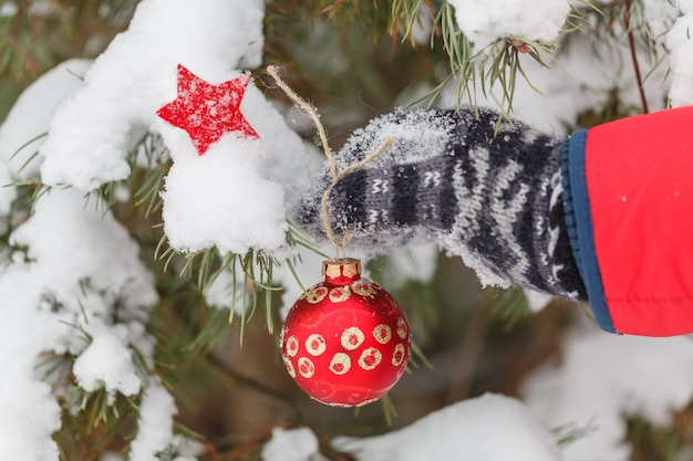 L'uomo decora un albero di pelliccia in legno d'inverno