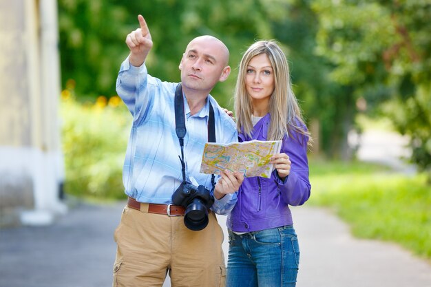 L'uomo del fotografo mostra nella direzione di una giovane ragazza sulla mappa