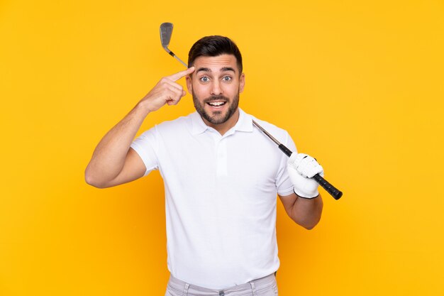 L'uomo del giocatore di golf sopra la parete gialla isolata che intende realizzare la soluzione