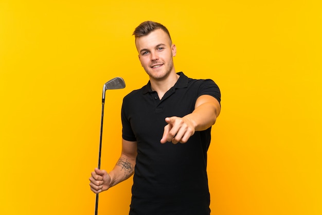 L'uomo del giocatore di golf sulla parete gialla indica il dito con un'espressione sicura