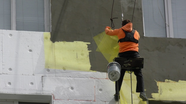 L&#39;uomo del lavoratore isola il grattacielo della parete