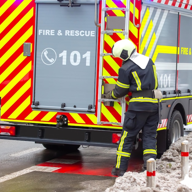 L'uomo del pompiere lavora sul suo servizio di sicurezza antincendio del camion dei pompieri