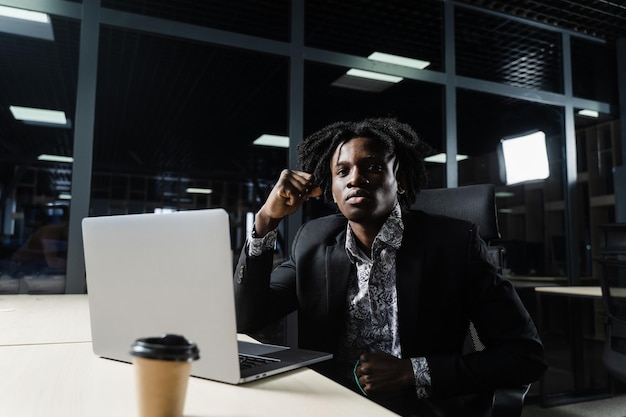 L'uomo di colore felice ha stretto i pugni e si è rallegrato di finire il suo lavoro online sul laptop. Lavorare online nello spazio di coworking.