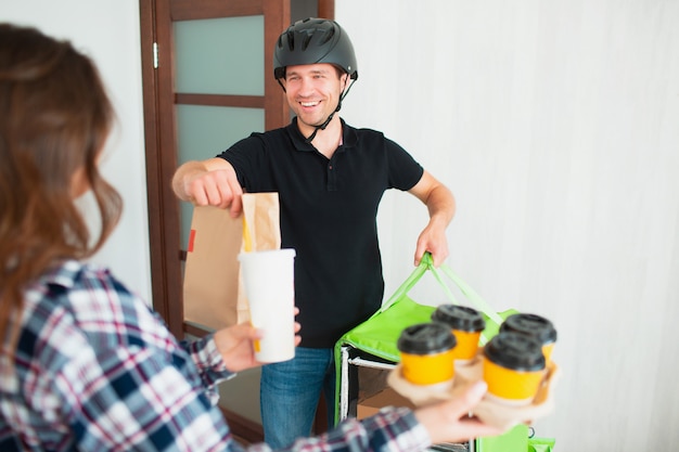 L'uomo di consegna dell'alimento ha portato l'alimento a casa alla giovane donna.