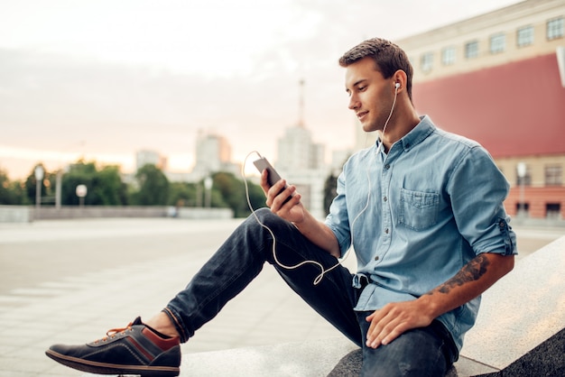 L'uomo dipendente dal telefono non può vivere senza gadget, problema di dipendenza, persone dipendenti dalla società, stile di vita moderno