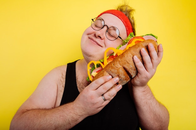 L'uomo divertente abbraccia un enorme hamburger