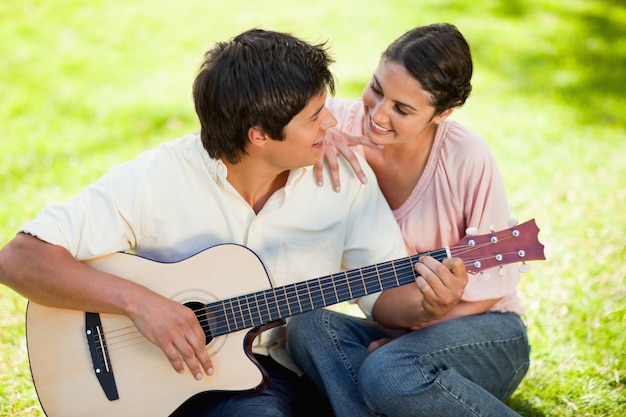 L&#39;uomo e il suo amico si guardano mentre suona la chitarra