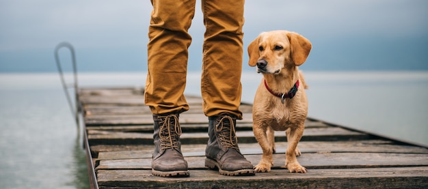 L'uomo e il suo cane in piedi sul molo