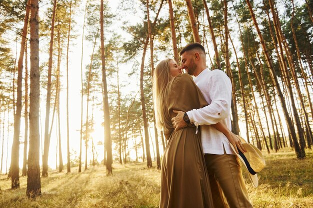 L'uomo è in camicia bianca e la donna in abito La coppia felice è all'aperto nella foresta durante il giorno