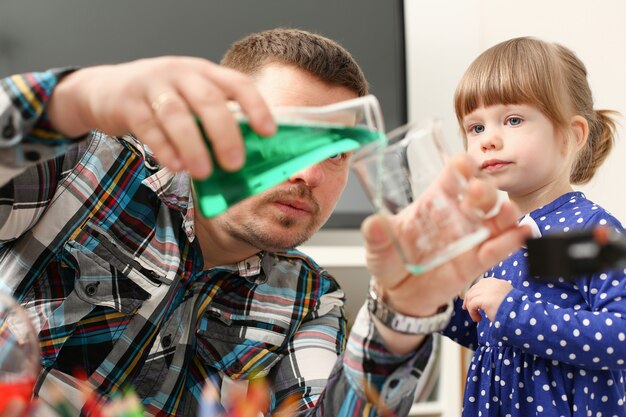 L'uomo e la bambina giocano con liquidi colorati