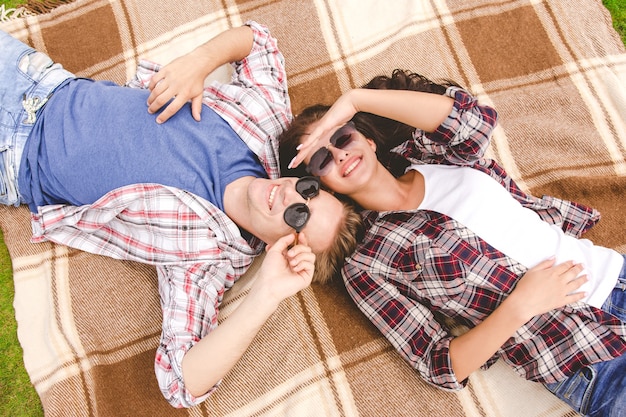 L'uomo e la donna con gli occhiali da sole giacevano a terra