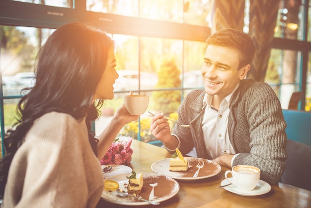 L'uomo e la donna felici bevono un caffè al bar