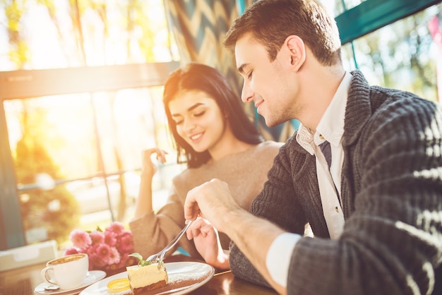 L'uomo e la donna felici che mangiano il dessert al bar