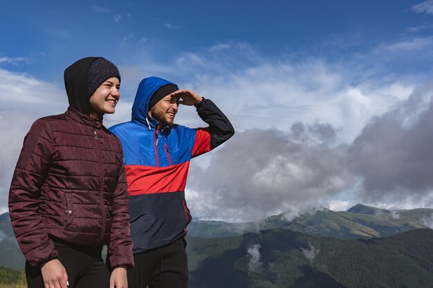 L'uomo e la donna felici in piedi su una montagna con una bellissima vista