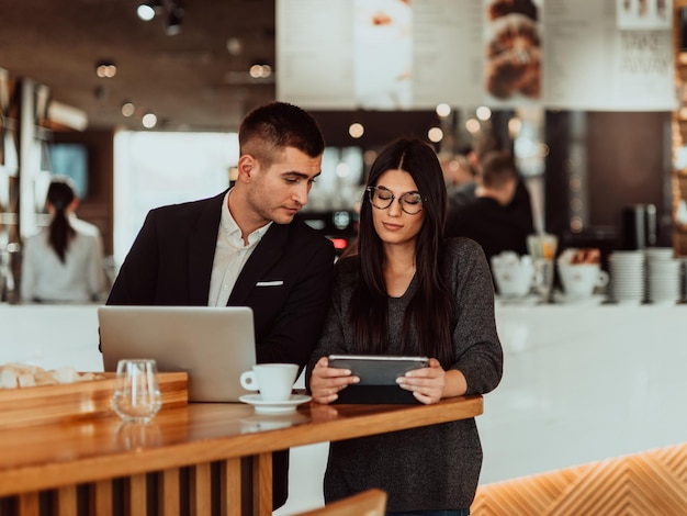 l'uomo e la donna moderni utilizzano dispositivi moderni, laptop, tablet e smartphone e organizzano nuovi progetti per il lavoro. Concetto di affari.