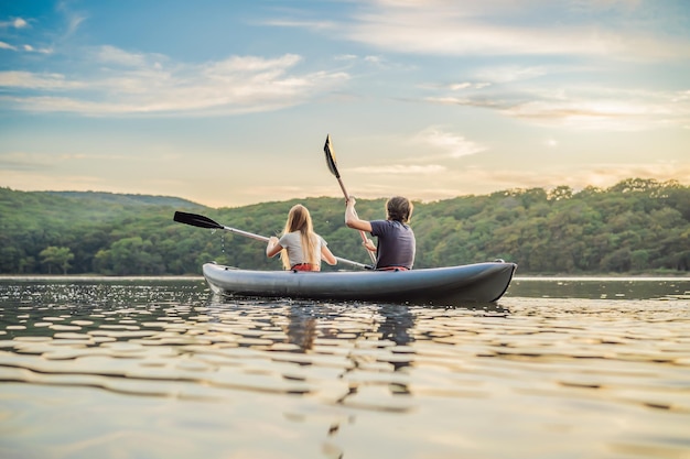 L'uomo e la donna nuotano in kayak nel mare sullo sfondo dell'isola Concetto di kayak Concetto di kayak con la famiglia di padre madre in mare