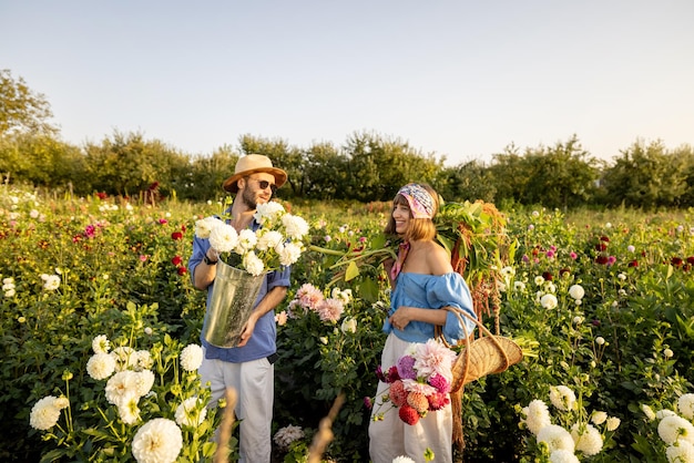 L'uomo e la donna raccolgono i fiori in una fattoria all'aperto